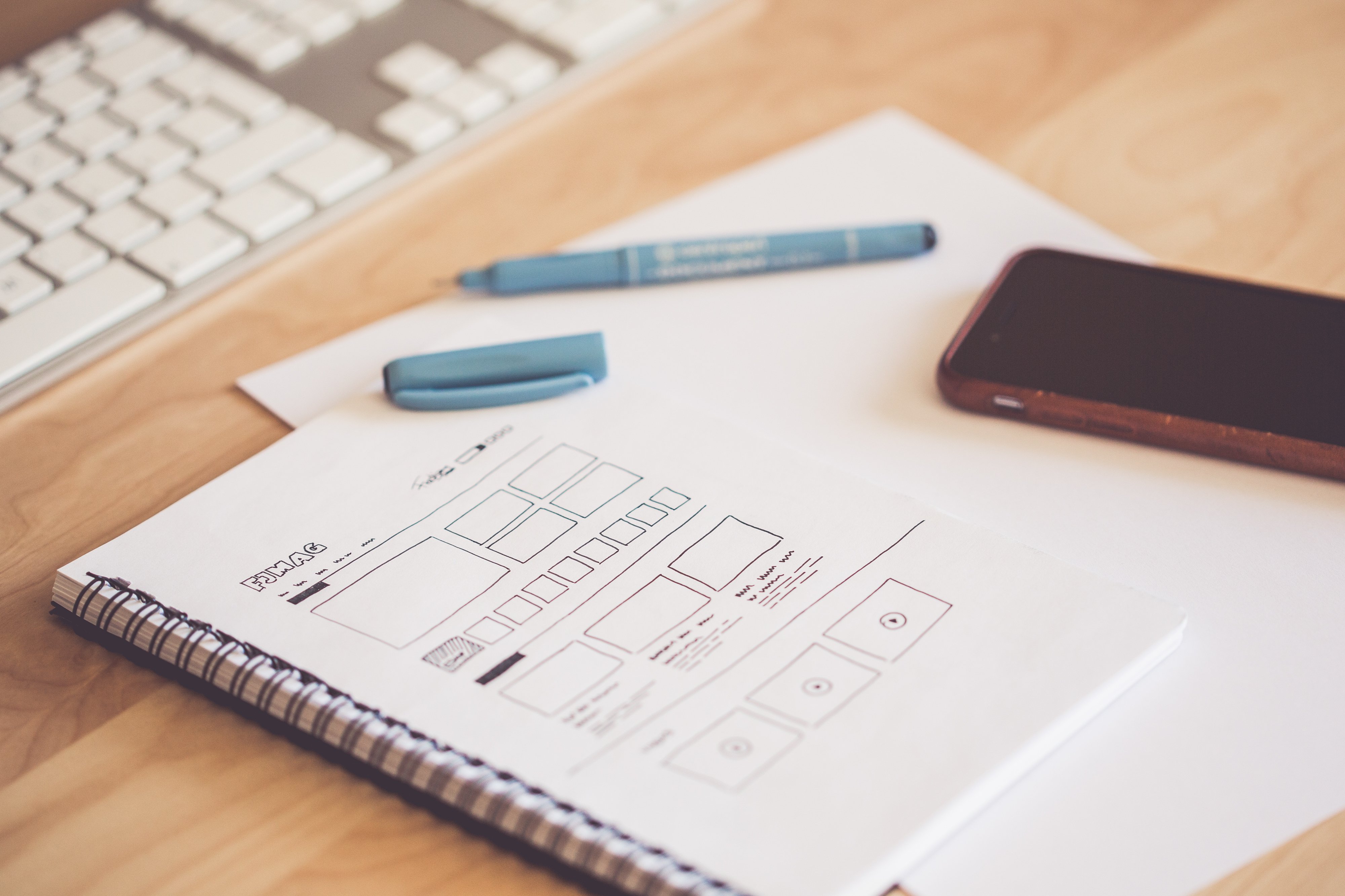 Canva - Blue Pen Beside Black Smartphone on White Paper